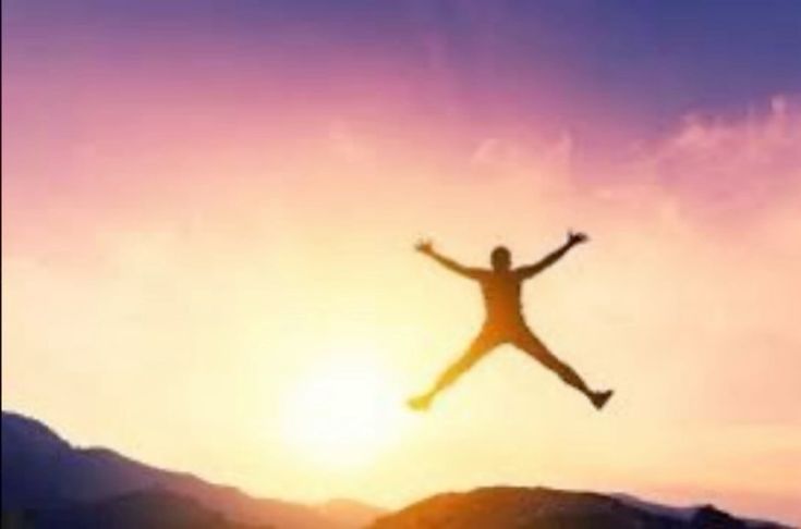 Low-res image of a person jumping happily at sunrise