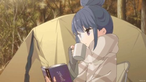 a girl is reading a book and drinking from a mug in front of a tent