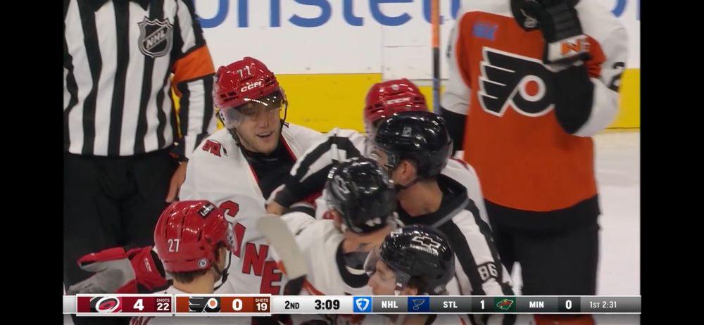 Mark Jankowski smiling mid scrum.
he shrugs with one arm 