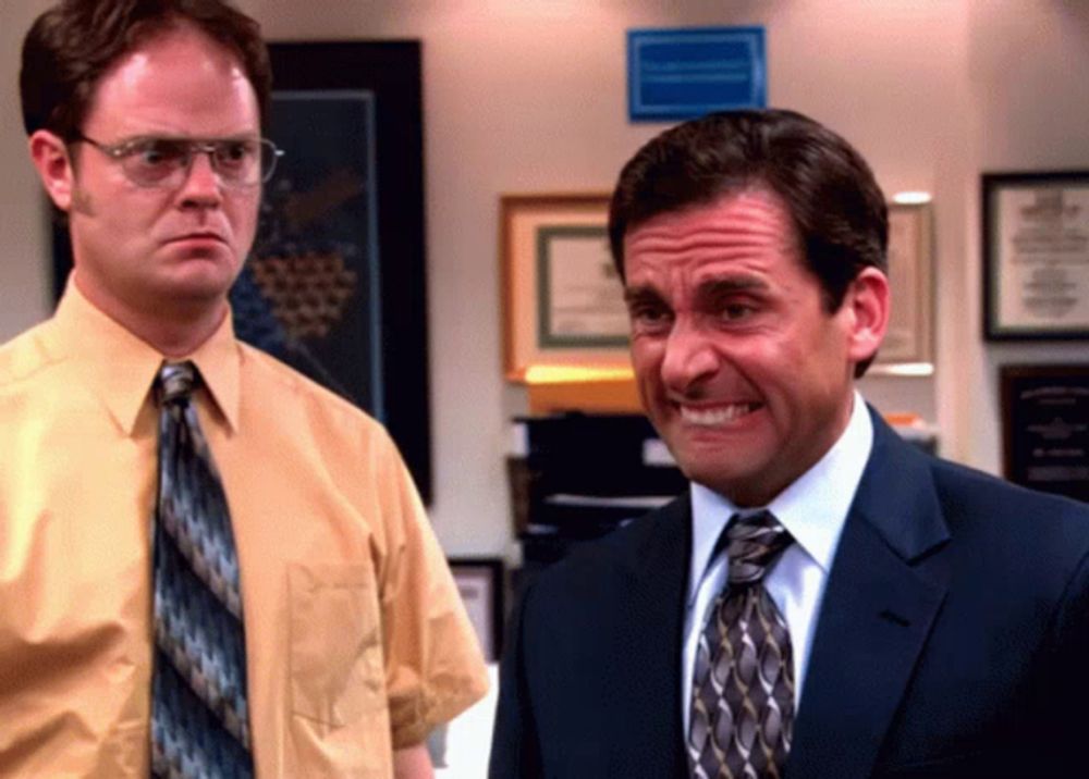 dwight schrute and michael scott are standing next to each other in an office