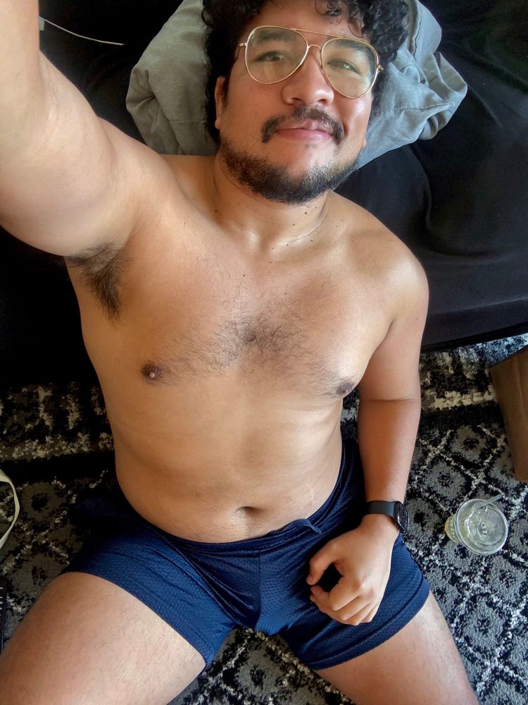 Sitting on the floor in blue workout shorts