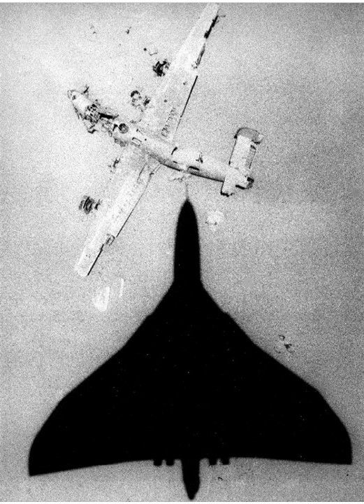 A Vulcan bomber overflies a crashed B-24 Liberator in Libya