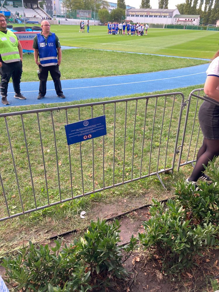 Bilde av fotballstadion. Hekker foran gjerdet på ene tribuna 