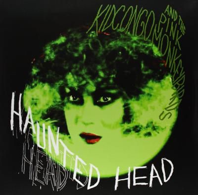Light green circle with the face of a person's head with red lipstick and deep black eye shadow. Titling in scratchy hand drawn letters say "Kid Kongo and the Pink Monkey Birds" in the upper right corner and "Haunted Head" in the lower left.