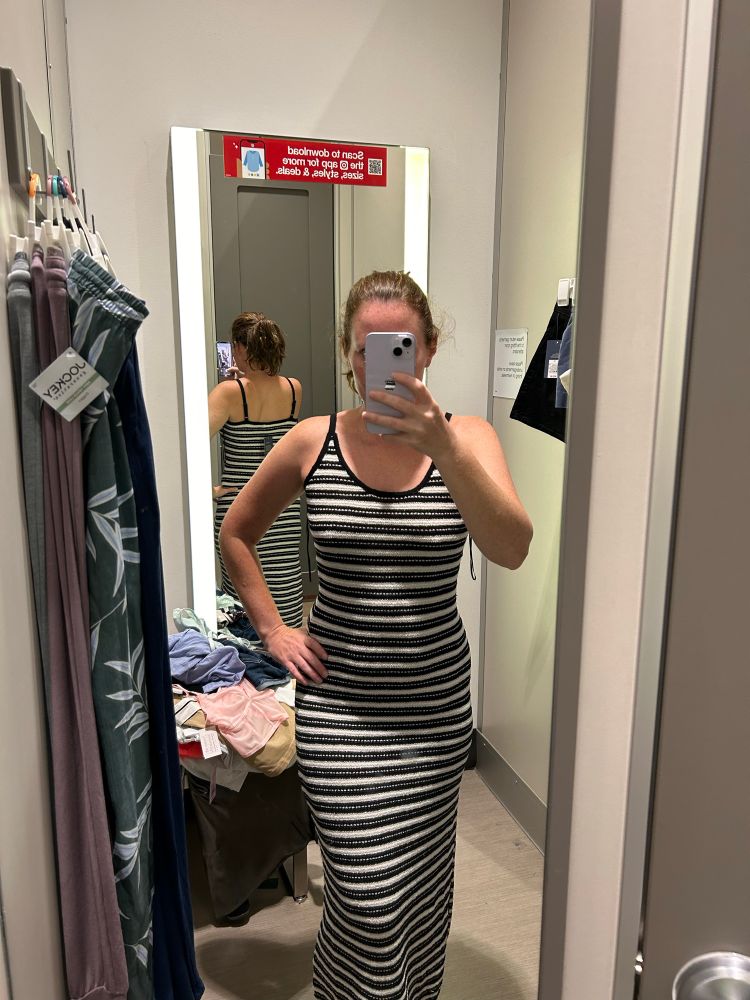 Women in changing room trying on long dress