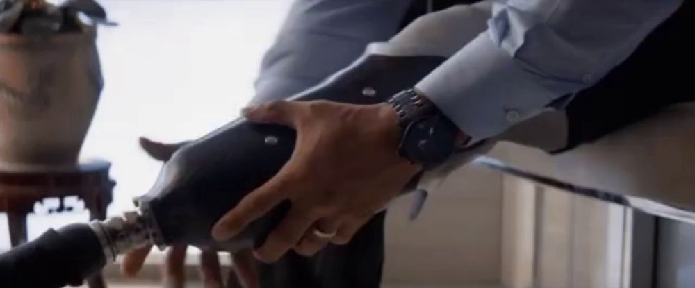 a man wearing a watch is holding a prosthetic leg in his hand .