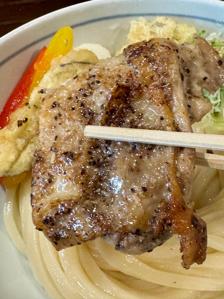 増田うどん 黒胡椒チキンぶっかけ(冷)
黒胡椒チキンを箸で持ち上げたところ
胡椒もかかっていますが、程よくピリッとする程度です。