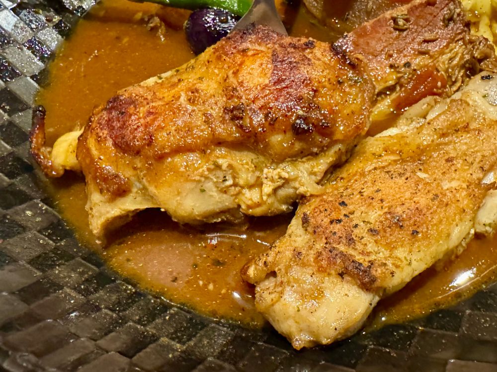 スープカレーHIGUMA(ヒグマ)
龍祈チキン&角煮スープカレー
表面がパリパリに焼かれたチキン
チキンは通常は骨ありのようですが、このメニューじゃない通常のチキンカレー含め、現在骨なしでの提供のようです。