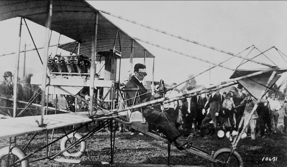 Glenn L. Martin, wearing warm clothes and flying goggles sits in an open frame biplane between an exposed 8 cylinder engine and a forward canard on struts. 

As Princess Leia would later say "You came here in that thing? You're braver than I thought."