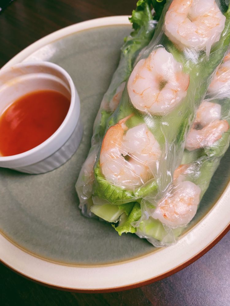 お皿にのった三本のえび入り生春巻きとスウィートチリソース。