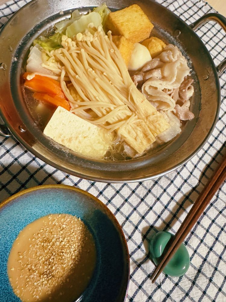 ステンレスの一人用寄せ鍋、ごまだれの入った器と箸、箸置き。