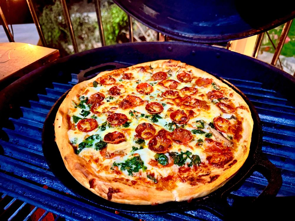 Sexy pizza on a grill, pepperoni, spinach, mushroom and tons of cheese in a pan style