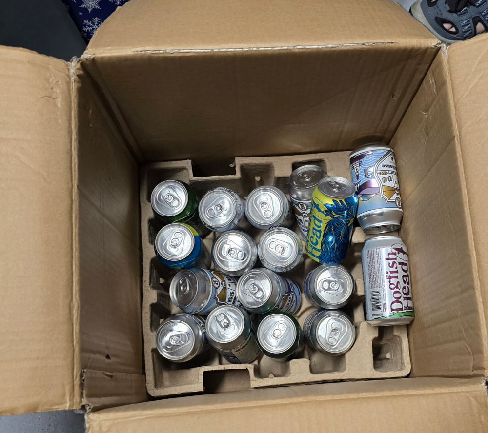 Cans of beer in a cardboard box. 