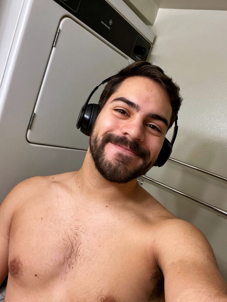 Guy wearing headphones and looking at the camera with brown eyes