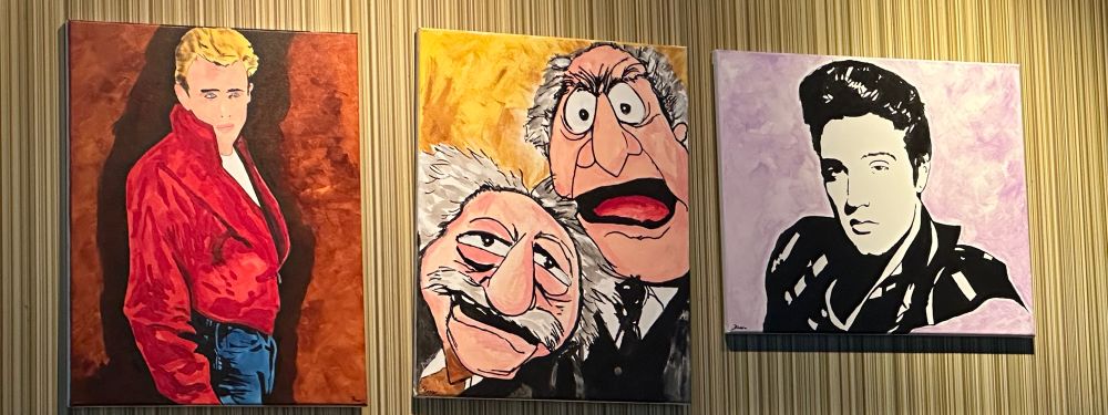 Three paintings: James Dean is on the left, Elvis is on the right, and with pride of place in the center, Statler and Waldorf. 
