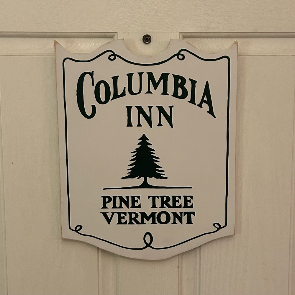 A wooden sign that says “Columbia Inn, Pine Tree, Vermont.”