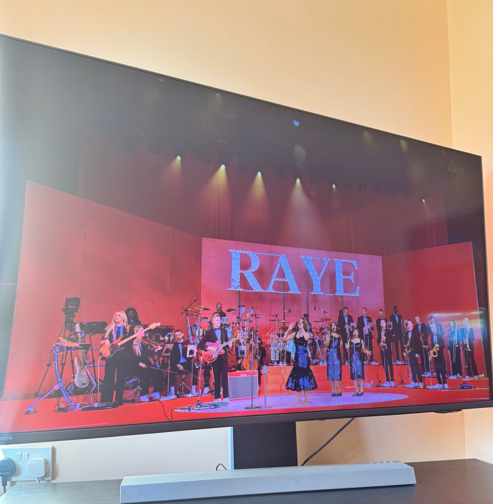 Picture of a screen playing Raye’s set at Glastonbury. 