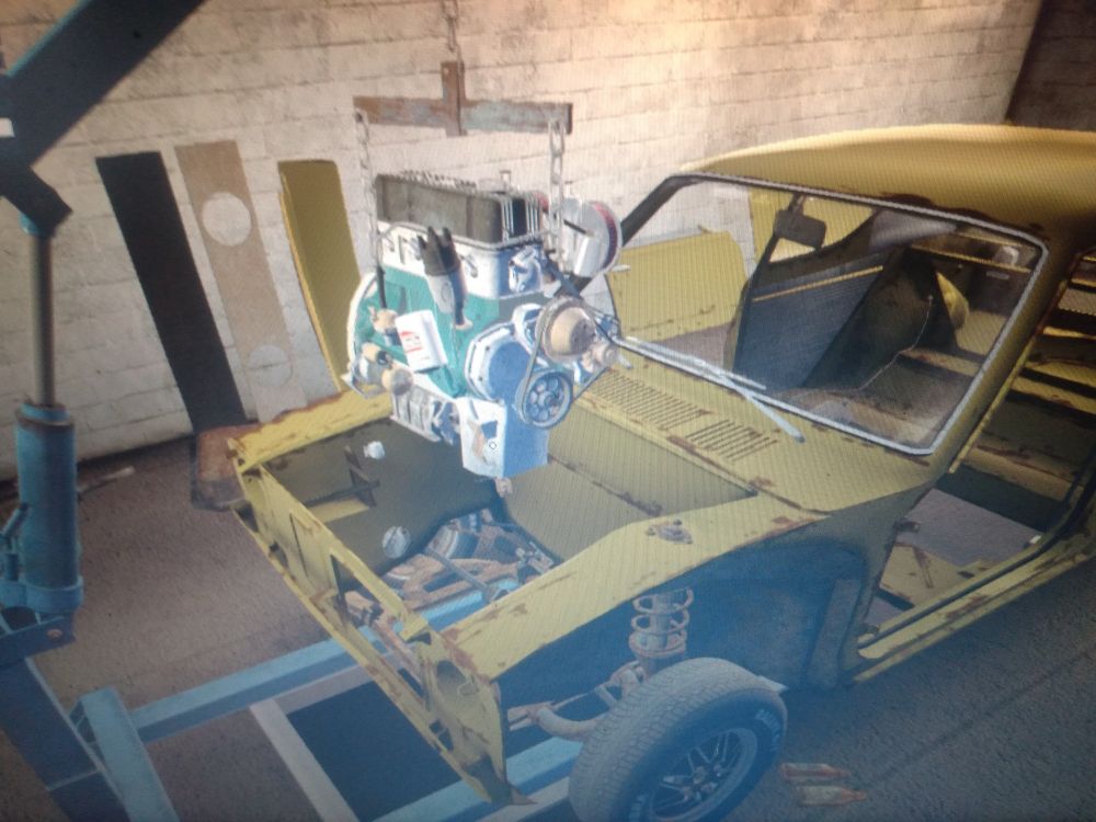 Engine hanging on a motor lift waiting to be mounted in the engine well