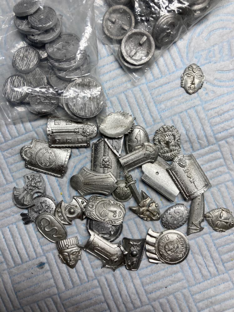 Pile of loose metal shields. Many different eras and designs 