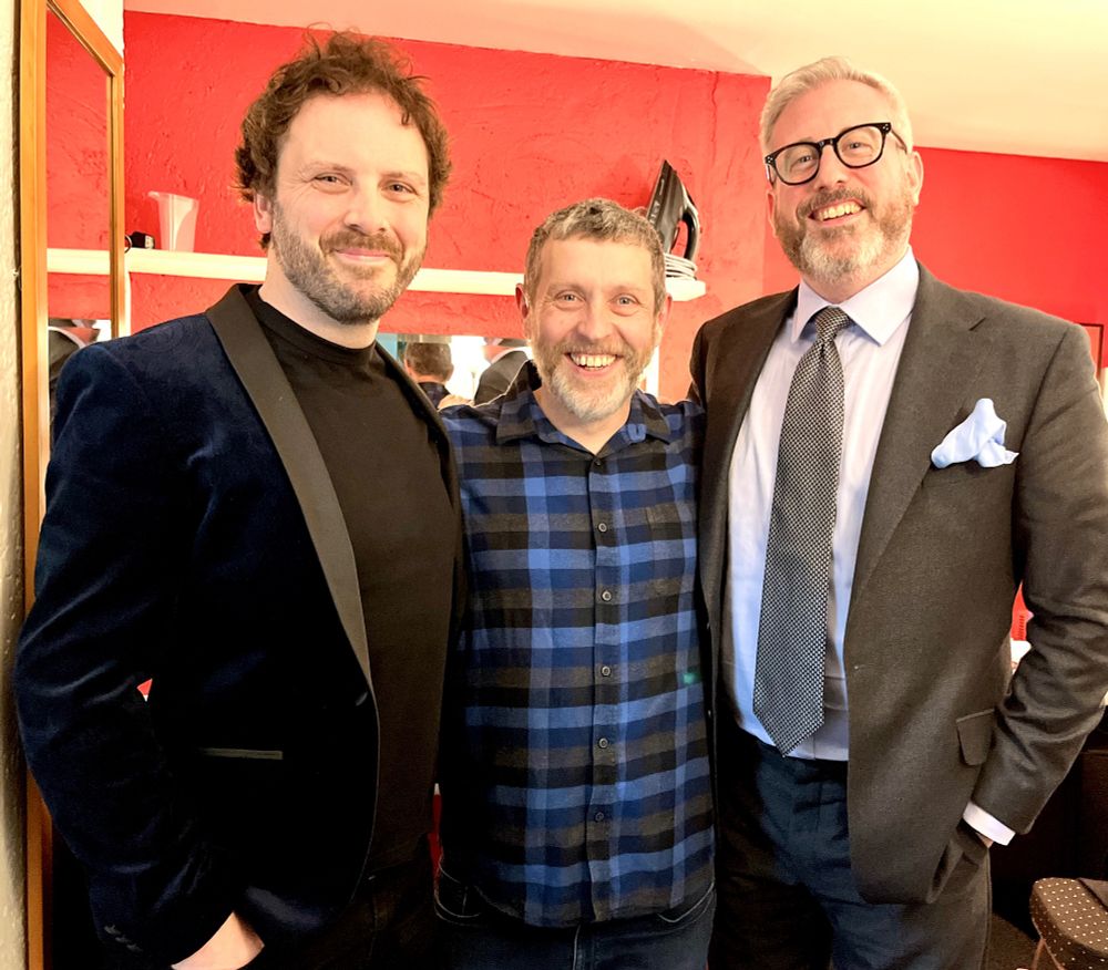 Larry, Dave Gorman and Paul standing next to each other, smiling.