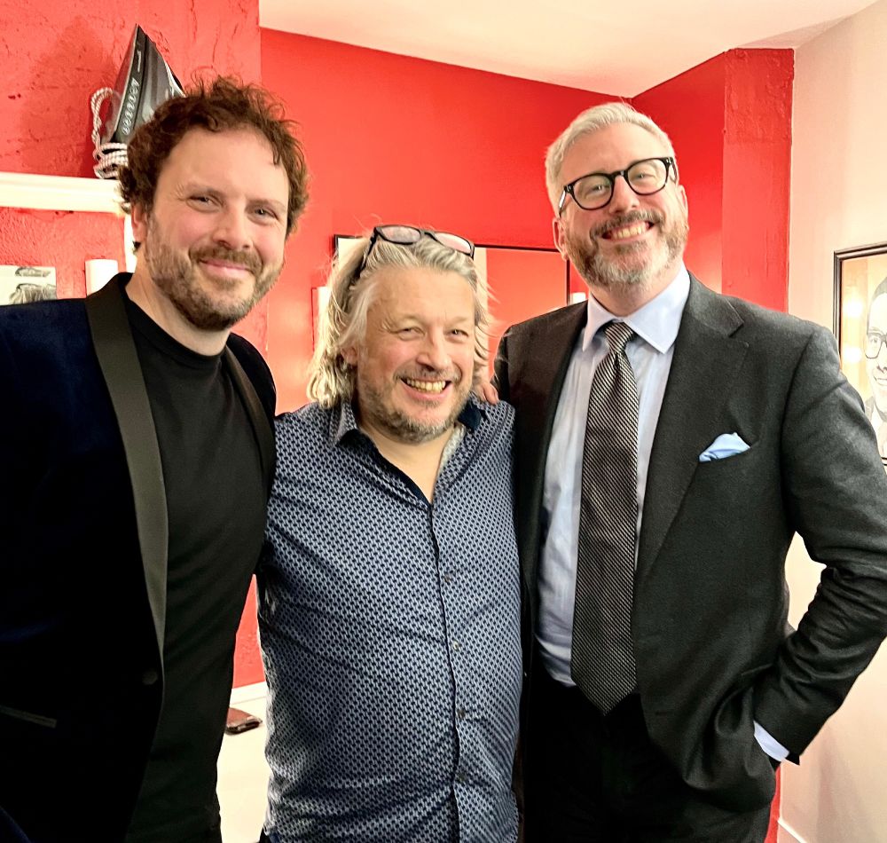 Larry, Richard Herring and Paul standing next to each other and smiling at the camera.