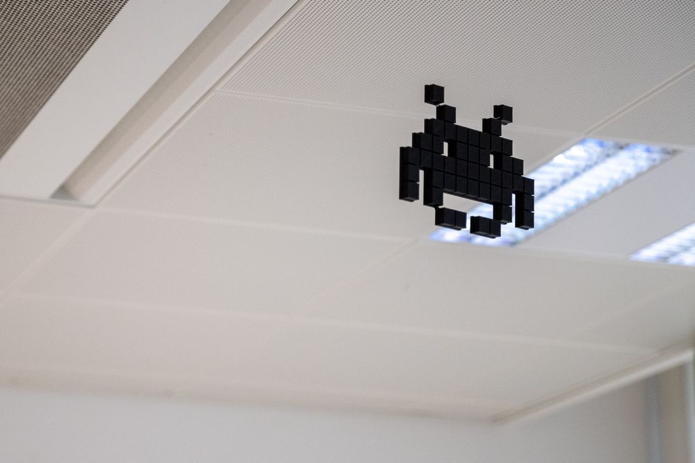 Eine Figur aus dem Video Spiel Space Invaders hängt von einer Decke.