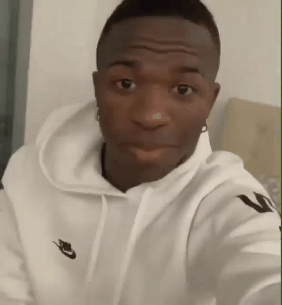 a man wearing a white nike hoodie is looking at the camera