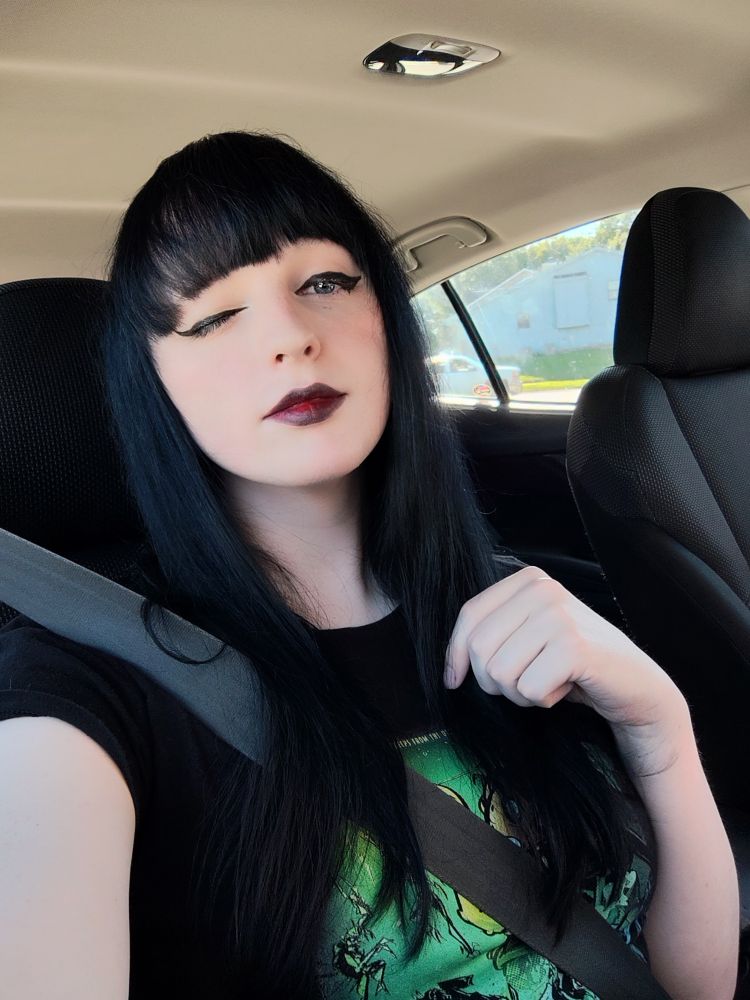 A selfie of me winking with dark lipstick and eyeliner on