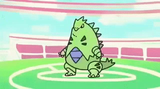 a cartoon of a green dinosaur standing on top of a green field .