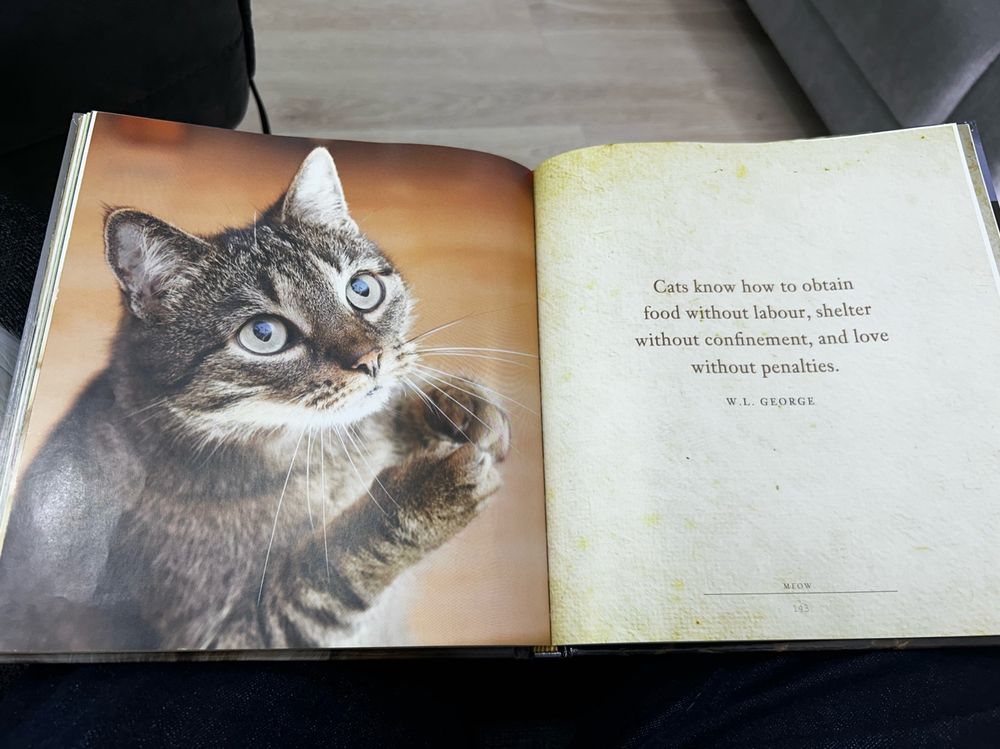 Cat book with caption "cats know how to obtain food without labor, shelter without confinement and love without penalties".