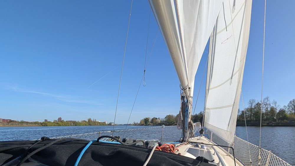 Ein Segelboot bei leichtem Wind und blauem Himmel auf der Weser.