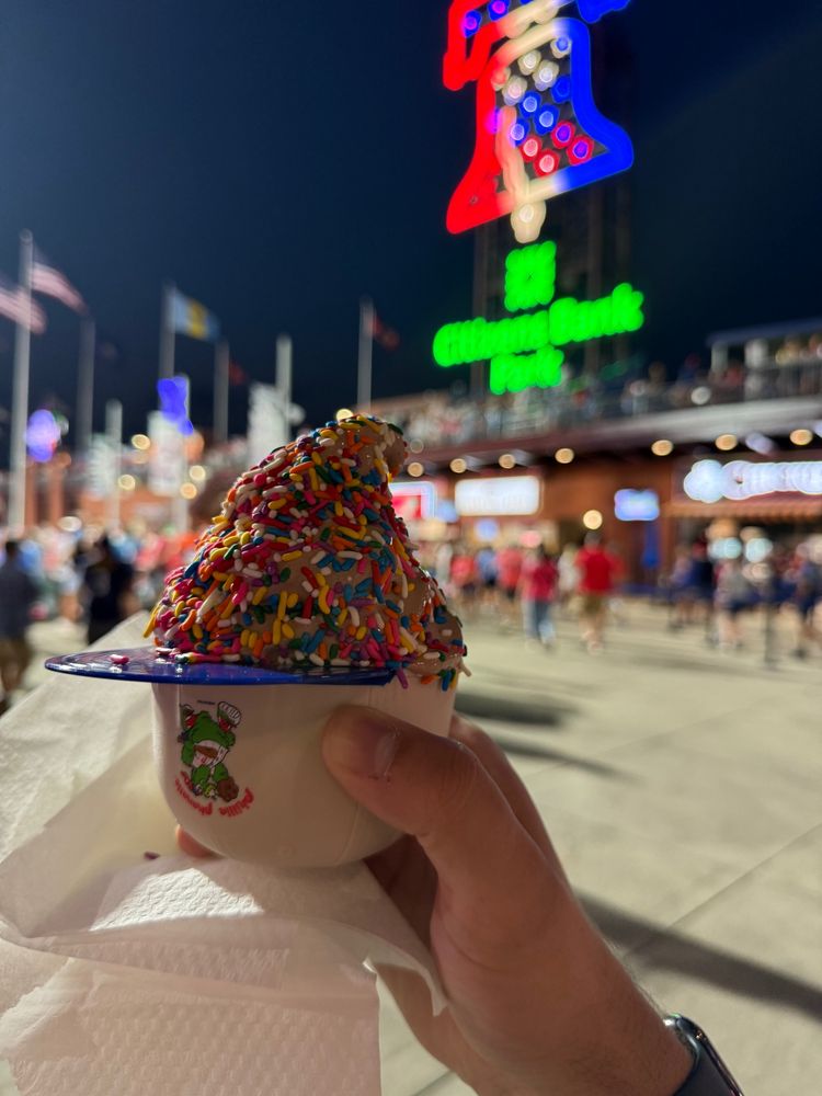 Ice cream in a mini baseball cap in front of the bell. 