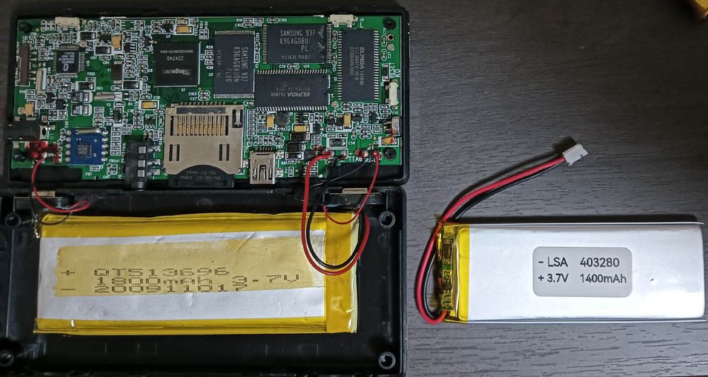 The Dingoo with its larger old battery 5.1x36x96mm but dead next to a new battery 4.0x32x80mm.