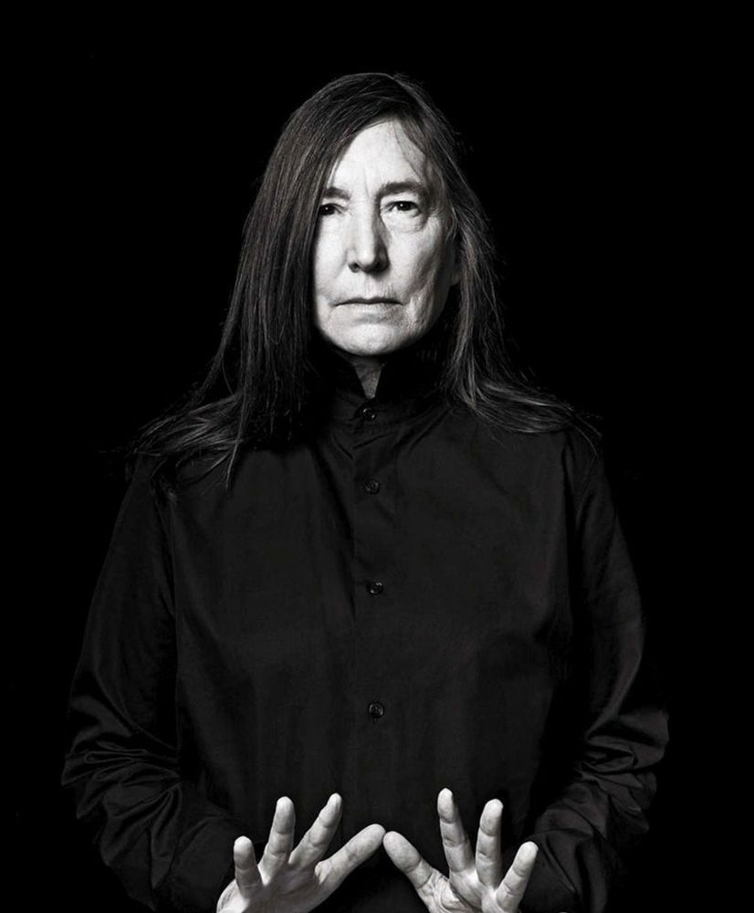 Jenny Holzer wearing all black with low jazz hands.