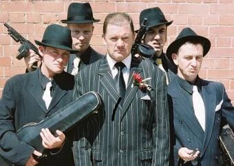 head monster next to a crew of goons and lackeys 