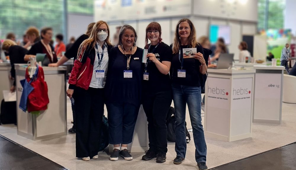 Personen posieren für ein Gruppenfoto in einer Messehalle