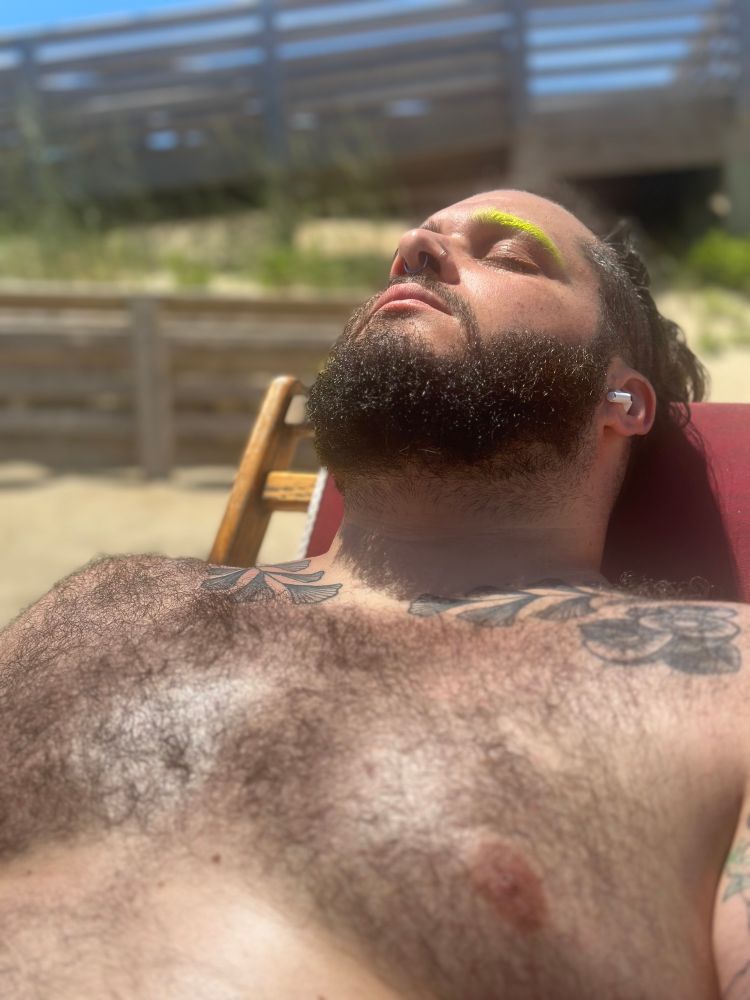 Eric laying out in the sun shirtless showing off his hairy chest. 
