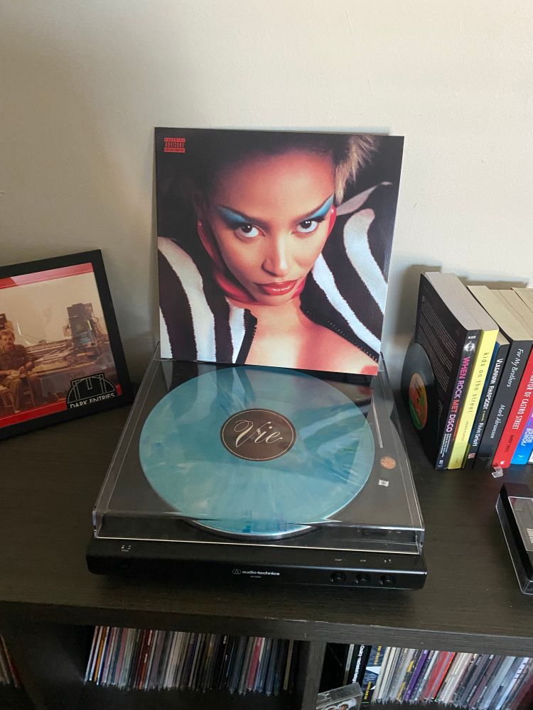 Vinyl cover sleeve of Vie (Words of Affirmation Edition) by Doja Cat sitting on top of a record player 