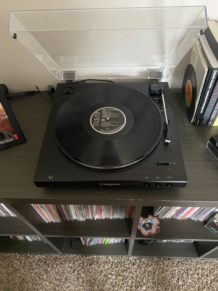 12” black vinyl disc sitting in a record player 
