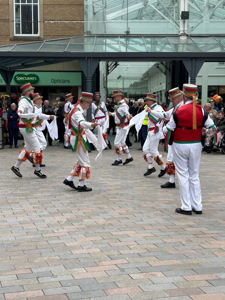 Troop of traditional Morris dancers dancing in Stockport market square.