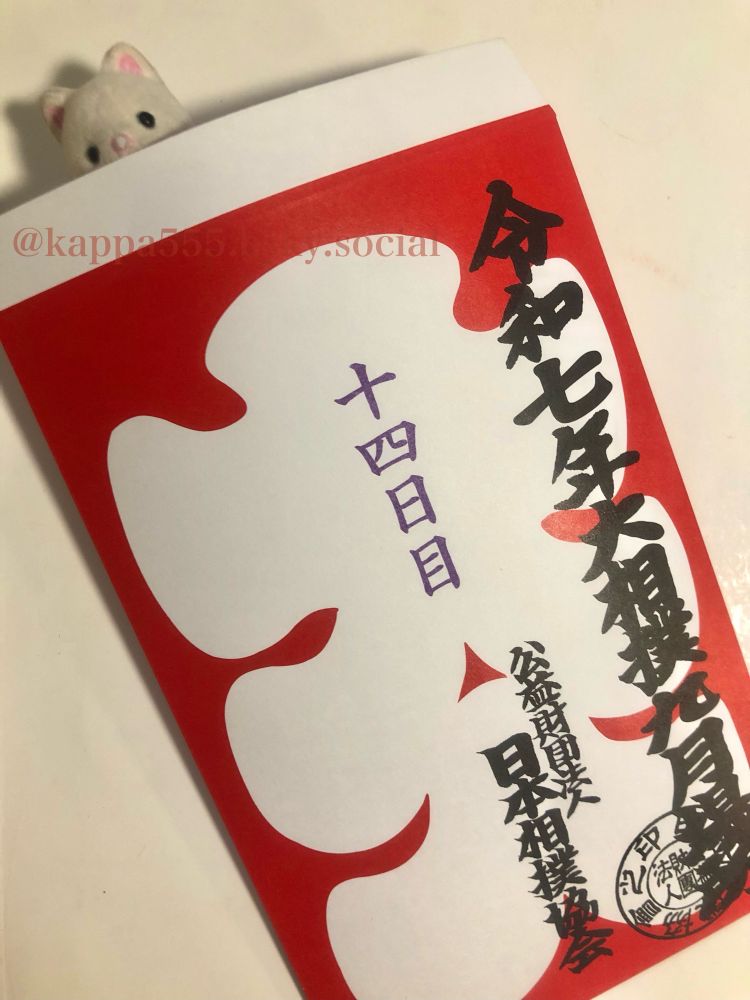 「令和七年大相撲九月場所　公益財団法人日本相撲協会」と相撲字で書かれ、「十四日目」とスタンプの押された大入袋に入り込んでるシルバニア赤ちゃん（シルクネコ）ぬい撮り写真です
