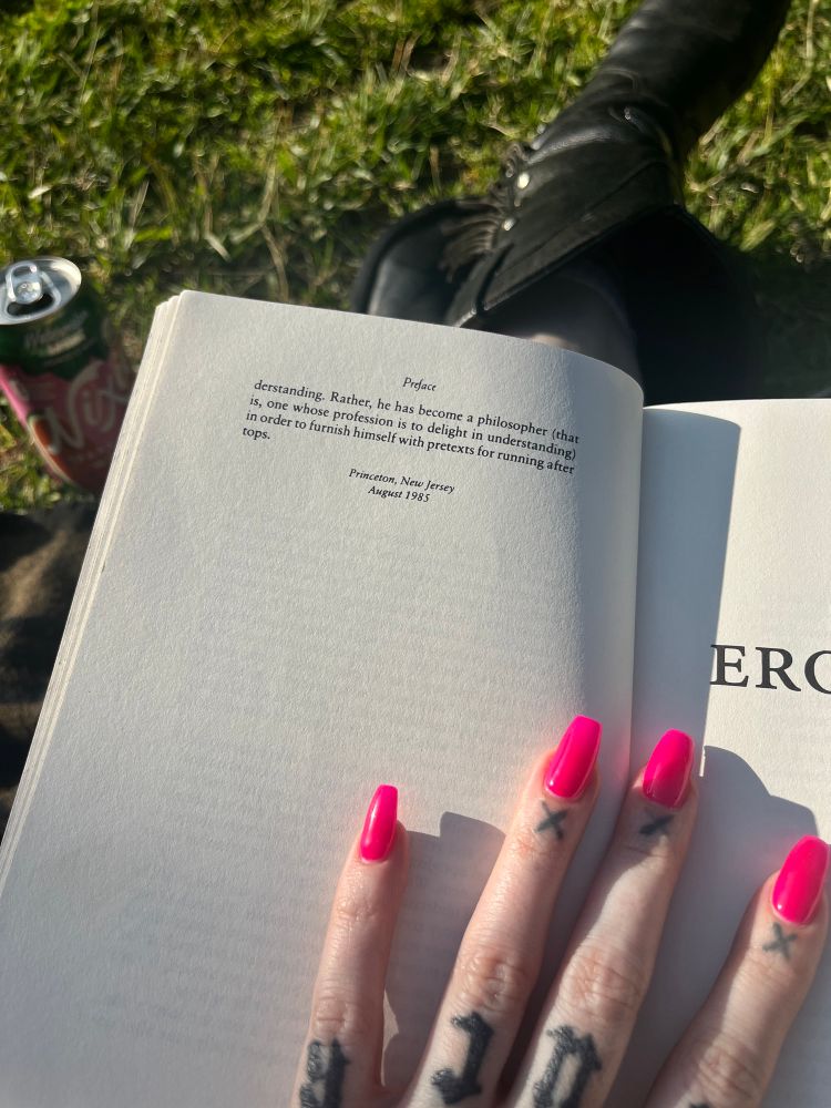 Hot pink manicured hand holds open the forward to Eros The Bittersweet by Anne Carson