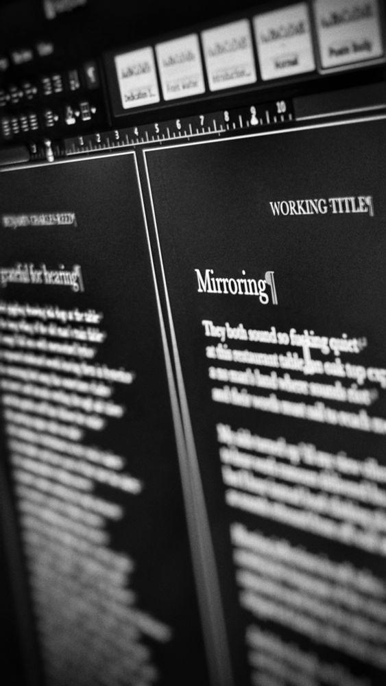 Blurred image of a Word document showing fragments of poems being formatted.