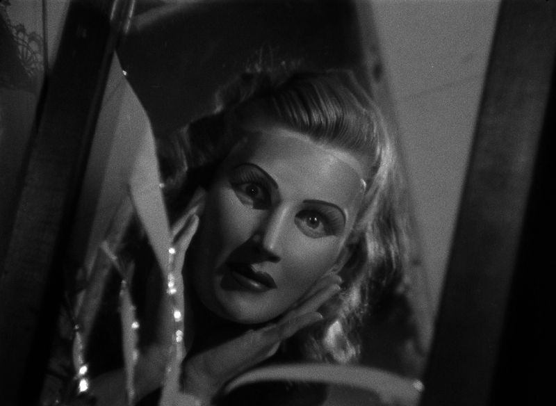 Betty Field as Henrietta donning a mask to hide her ugliness in the first segment of Flesh and Fantasy (1943).