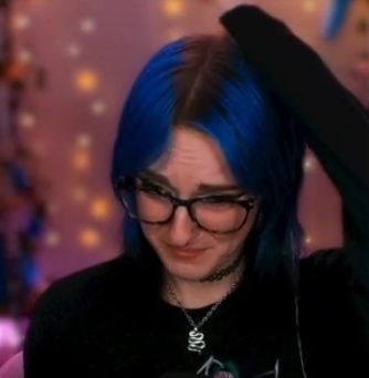 kat looking painfully sad with her hand on her head 