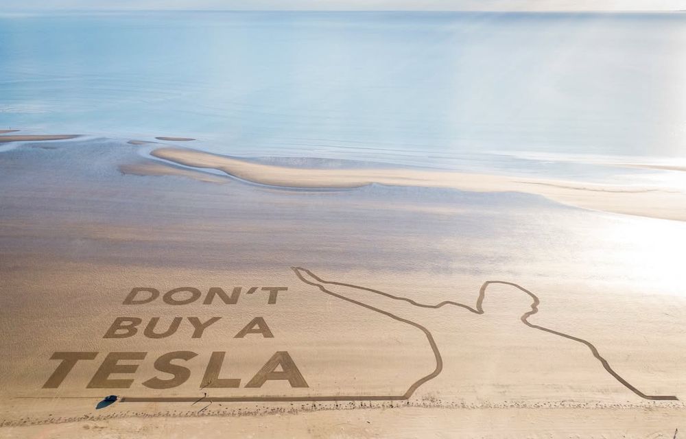 Ein Strand aus der Luft: jemand hat in den Sand riesig geschrieben „Don‘t buy a Tesla“
