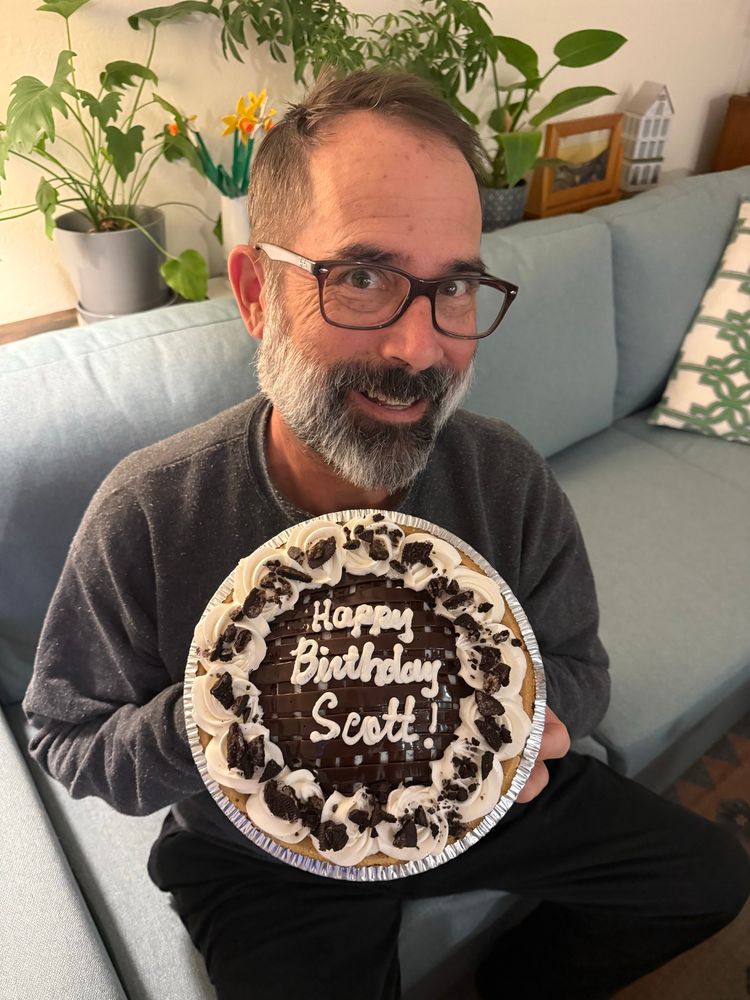 Picture of a man on a couch with a Baskin/Robbins ice cream pie - the pie reads Happy Birthday Scott 