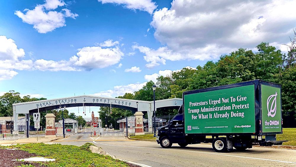 Outside North Chicago’s Great Lakes Naval Base, where federal troops are stationed, the Onion News Network truck displays “Protesters Urged Not to Give Trump Administration Pretext for What It Already Doing.”
