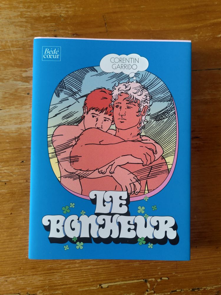 Couverture de la bande dessinée Le Bonheur de Corentin Garrido avec des hommes torses nus qui s'enlacent sur un fond bleu.