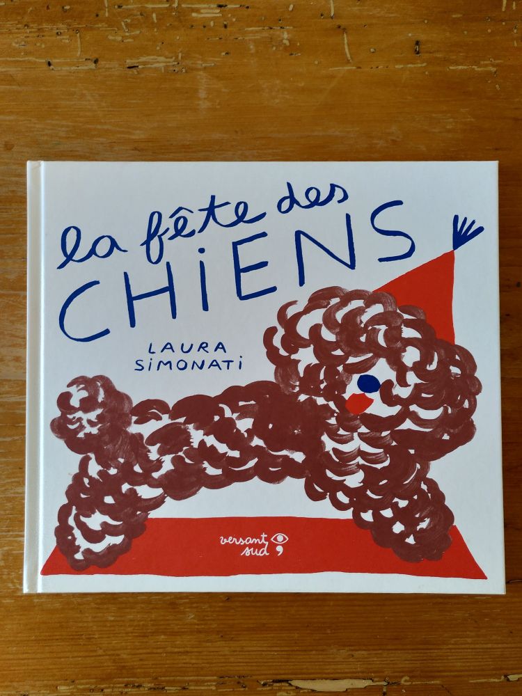 Couverture du livre La Fête des Chiens de Laura Simonati où l'on voit un chien marron au poil frisé avec un petit chapeau conique rouge sur la tête.
